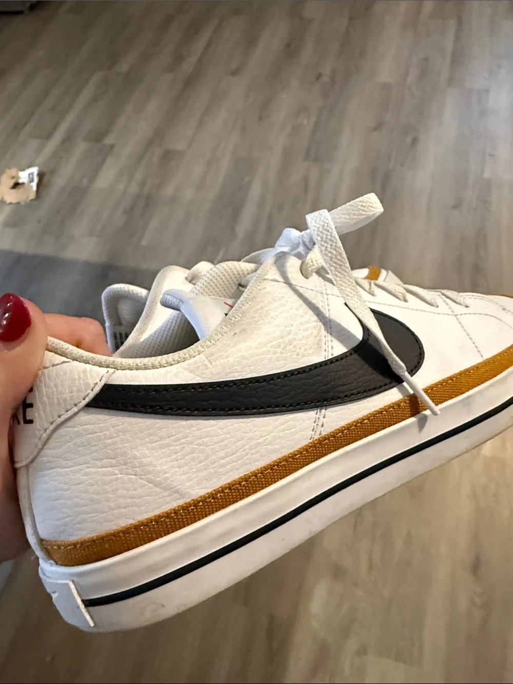 Nike Men’s White Low-Top Sneaker with Black Swoosh and Gold Accent